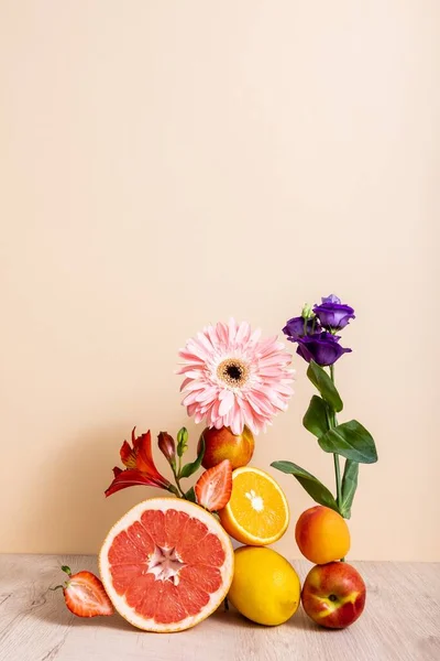 Composizione floreale e fruttata con Eustoma, gerbera, Alstroemeria, agrumi, fragole e pesche su fondo beige — Foto stock