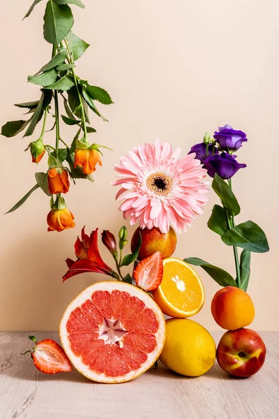 Floral and fruit composition with roses, Eustoma, gerbera, Alstroemeria, citrus fruits, strawberries and peaches on beige background — Stock Photo