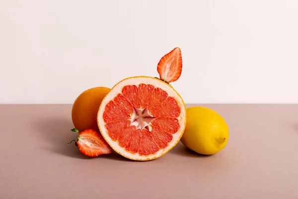 Fruit composition with citrus fruits and strawberry isolated on beige — Stock Photo