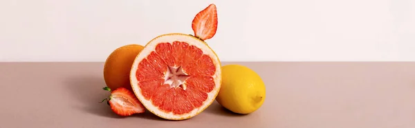 Fruit composition with citrus fruits and strawberry isolated on beige, panoramic crop — Stock Photo