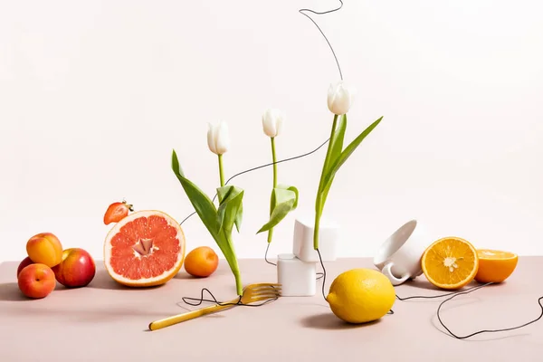 Composizione floreale e di frutta con tulipani, frutta, stoviglie isolate su beige — Foto stock