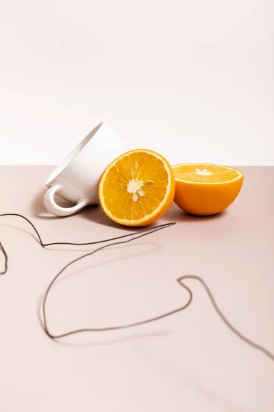 Fruit composition with wire, orange, cup isolated on beige — Stock Photo