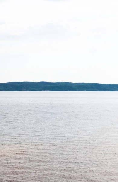 Lac propre et bleu contre le ciel en été — Photo de stock