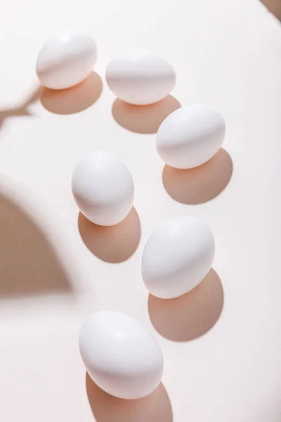 White chicken eggs for breakfast on grey table with shadows — Stock Photo