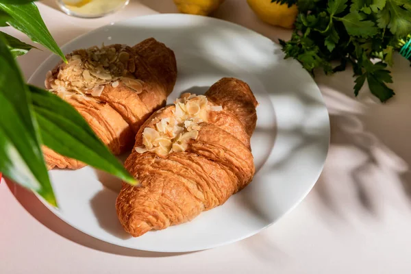 Croissants frais sur assiette pour le petit déjeuner sur table grise — Photo de stock