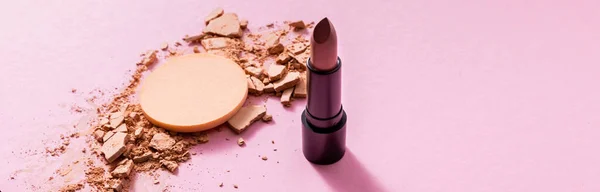 Panoramische Ausrichtung von rissigem Gesichtspuder in der Nähe von Make-up-Schwamm und Lippenstift auf rosa — Stockfoto