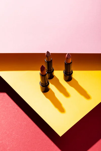 Ombres près des rouges à lèvres sur jaune, pourpre et rose — Photo de stock