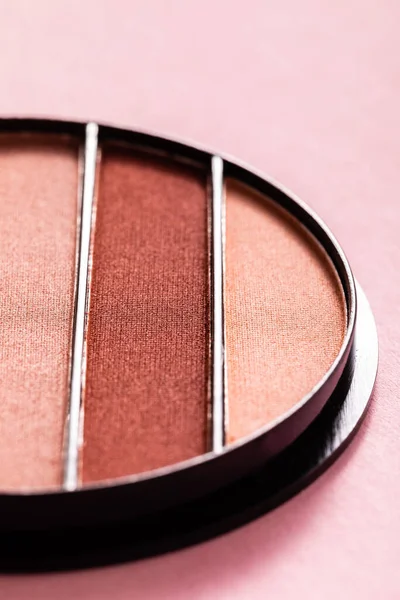 Close up of colorful pastel eye shadow palette on pink — Stock Photo