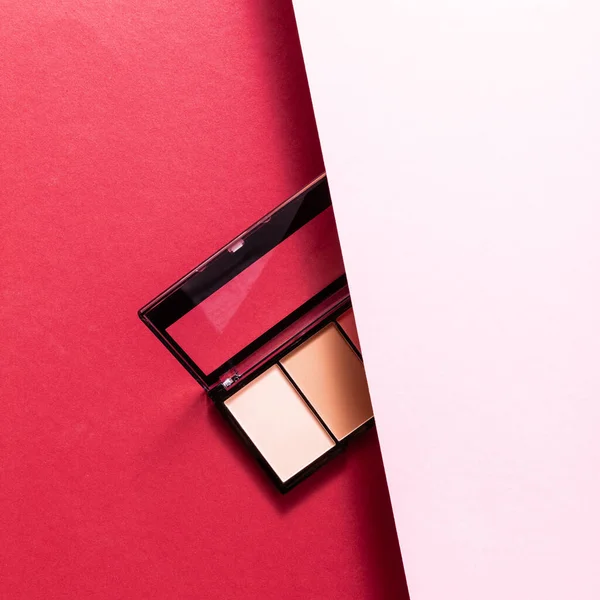 Top view of eye shadow palette on pink and crimson — Stock Photo