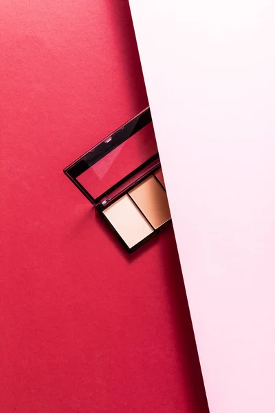 Top view of pastel eye shadow palette on pink and crimson — Stock Photo