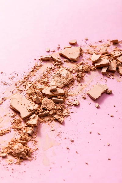 Beige and crushed face powder on pink — Stock Photo