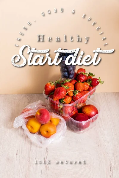 Fruit composition with blueberries, strawberries, nectarines and peaches in plastic containers near start diet lettering on beige — Stock Photo