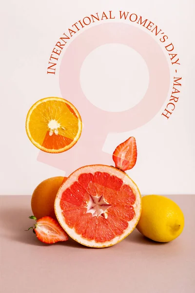 Fruit composition with citrus fruits and strawberry near international womens day march lettering on beige — Stock Photo