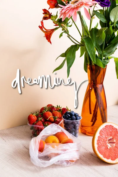 Blüten- und Fruchtkomposition mit Beeren, Grapefruit und Aprikosen in der Nähe traumhafter Schriftzüge auf Beige — Stockfoto