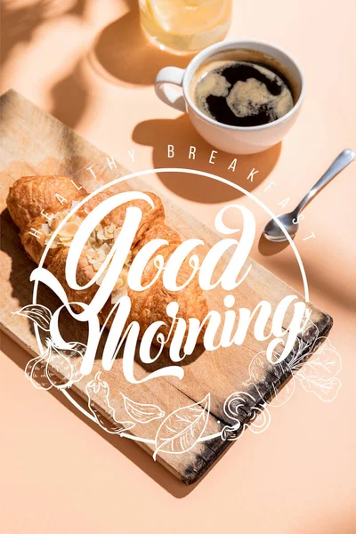 Cornetti freschi su tavola di legno e tazza di caffè per colazione su tavolo beige con colazione sana, lettering del giorno — Foto stock