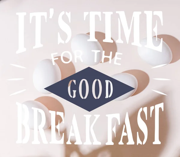 Top view of white boiled chicken eggs on grey table with it is time for the good breakfast lettering — Stock Photo