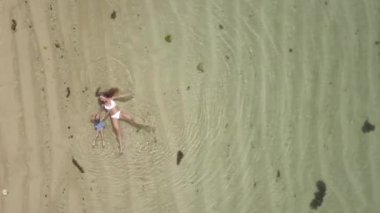 Havadan görüntüleri anne ve bebek sahilde deniz içinde yatan, dron suyun üstünde döner