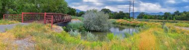 Ağaçlar, Rusya zeytin, cottonwood ve çamurlu dere boyunca Wasatch açık Rocky Dağları, Salt Lake City, Utah çevreleyen ile Ürdün Nehri Trail yaya ve görünümlerini tren Track Bridge.