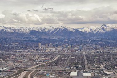 Şehir Merkezi Salt Lake şehir panoramik görünüm Wasatch Front Rocky Dağları kar ve bulutluk erime ile erken ilkbahar kış uçakta. Utah, Amerika Birleşik Devletleri.
