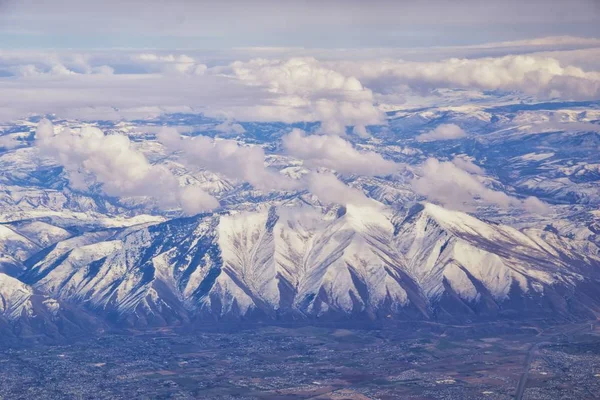 プロボ ファーミントンバウンティフル オレム ソルトレイクシティの都市を含む冬の雪のピークを持つワサッチフロントロッキー山脈の飛行機からの航空写真 — ストック写真