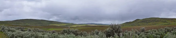 州間高速道路84 84からユタ州とアイダホ州の国境からの風景嵐のパノラマビュー ロッキー山脈の羊と牛の放牧地と農村農業の眺め — ストック写真