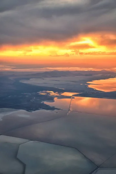 Great Salt Lake Sunset Aerial view from airplane in Wasatch Rocky Mountain Range, sweeping cloudscape and landscape during day time in Spring. In Utah, United States.