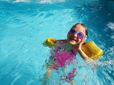 havuzda yüzen mutlu kız