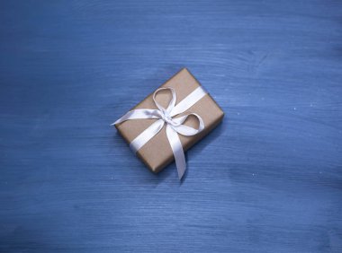 Düz sarılmış ve yay üzerinde mavi arka plan ile dekore edilmiş romantik hediye yatıyordu