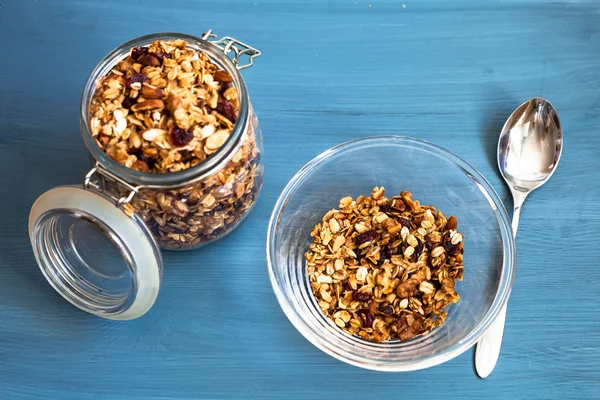 Zelfgemaakte muesli in een plaat op een blauwe achtergrond, gezond ontbijt van havermout, muesli, noten, zaden en gedroogde vruchten — Stockfoto