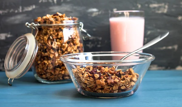 Muesli casero con yogur en un plato sobre un fondo azul, desayuno saludable de muesli de avena, nueces, semillas y frutas secas —  Fotos de Stock