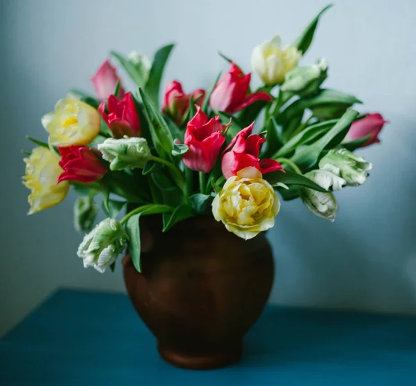 Bouquet de belles tulipes multicolores dans un vase sur fond bleu, gros plan — Photo