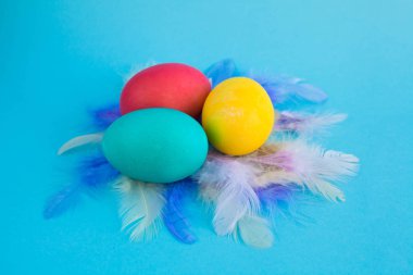 Bir boşaltmak bir mavi renk zemin üzerine sepetteki renkli Paskalya yumurtaları