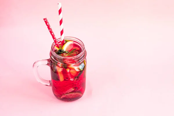 Jar of tasty cold lemonade on a pink background — Stock Photo, Image