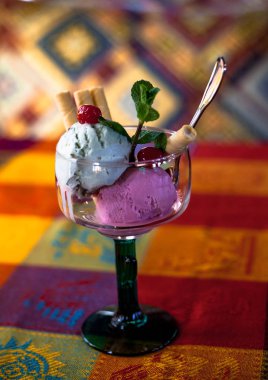 Renkli bir arka plan üzerinde bir waffle sopa ile cam bir fincan popsicles