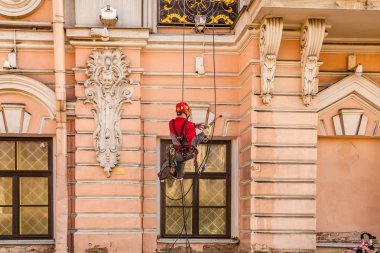 Haziran 2018, St. Petersburg, Rusya. Bir işçi binanın ön cephesini yıkıyor