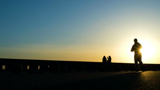 Silueta de un hombre corriendo en el parque al atardecer — Vídeos de Stock