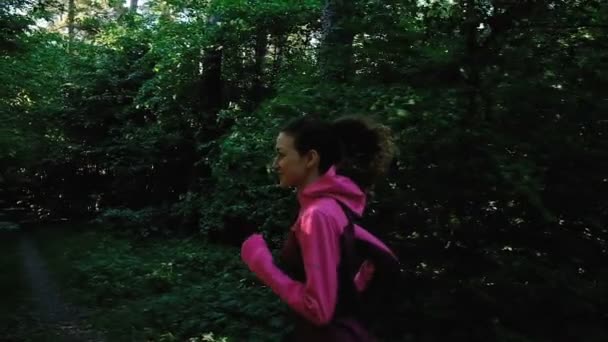 Молодая девушка бежит в лесу, женщина бежит в парке летом, замедленное движение камеры. Закрыть — стоковое видео