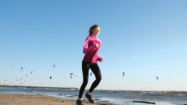 Yaz aylarında sahilde kitesurfers günbatımı, yavaş hareket, bir arka plan üzerinde çalışan kadın