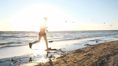 Plaj boyunca denizde koşan adam ve atlar bitirmek, ağır çekim
