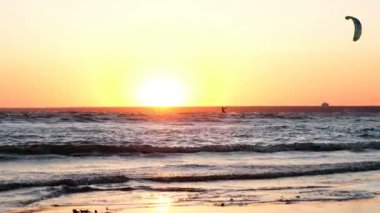 Yaz aylarında gün batımında denizde kitesurfer silüeti yakın çekim
