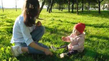 Mutlu genç anne çocuğunu bir dal parkta çim ile oynarken ile