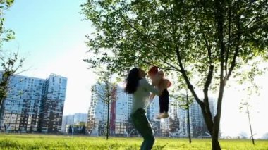 Anne Çocuk atar ve günbatımı, ağır çekim, parkta bebek döner.