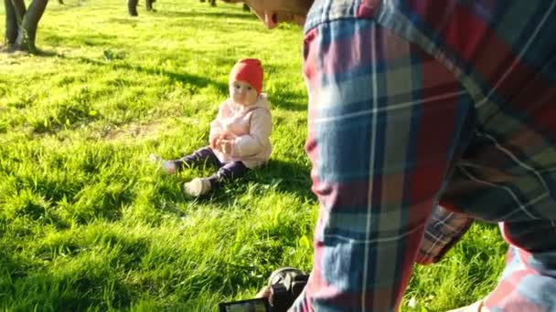 Junger Vater fotografiert Tochter bei Sonnenuntergang im Park. — Stockvideo