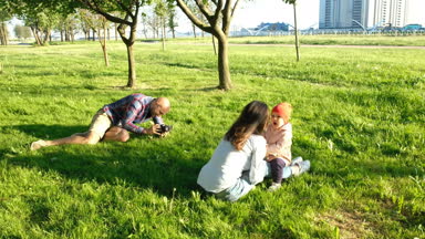 Genç baba küçük kızı annesiyle birlikte bir resim gün batımında parkta alır. Mutlu bir aile içinde doğa yürüyüşleri