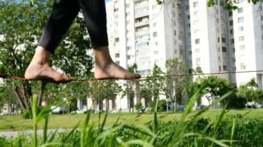 Avrupa kız bir şehir parkı sıkı bir satırda yürüyor. Kadın slackline Dengeleme yakın çekim