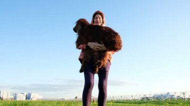 Kadın parkta köpek ile oynarken. Genç kız a evde beslenen hayvan çim, yavaş hareket yukarı atar