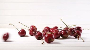 Kiraz meyveleri avuç beyaz bir arka plan üzerine düşmek