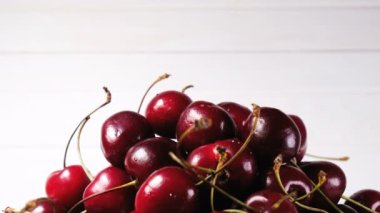 El bir kiraz büyük bir yığın üstüne beyaz bir arka plan üzerine koyar.