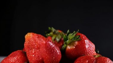 Bir çilek berry çilek bir avuç üstünde tepe-in karanlık bir arka plan üzerine düşüyor.