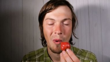 Avrupa delikanlı iştah açıcı olgun çilek yakın çekim yiyor. Olgun meyve zevk ile aç çocuk yer